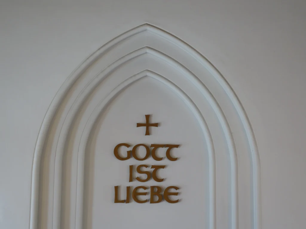 Gott ist Liebe - Die zentrale Botschaft über unserer Kanzel im Kirchensaal.