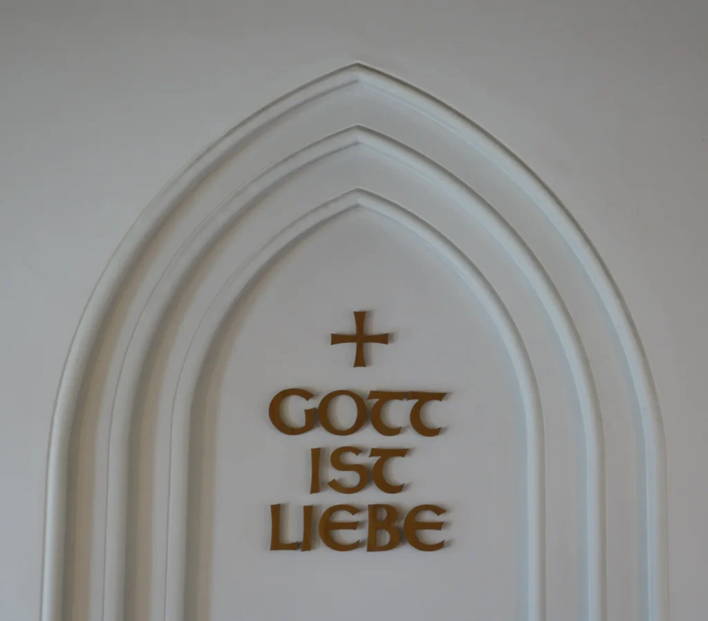 Gott ist Liebe - Die zentrale Botschaft über unserer Kanzel im Kirchensaal.